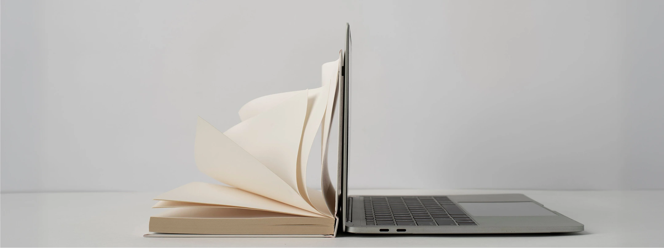 Open book beside a laptop, representing ebooks and digital resources